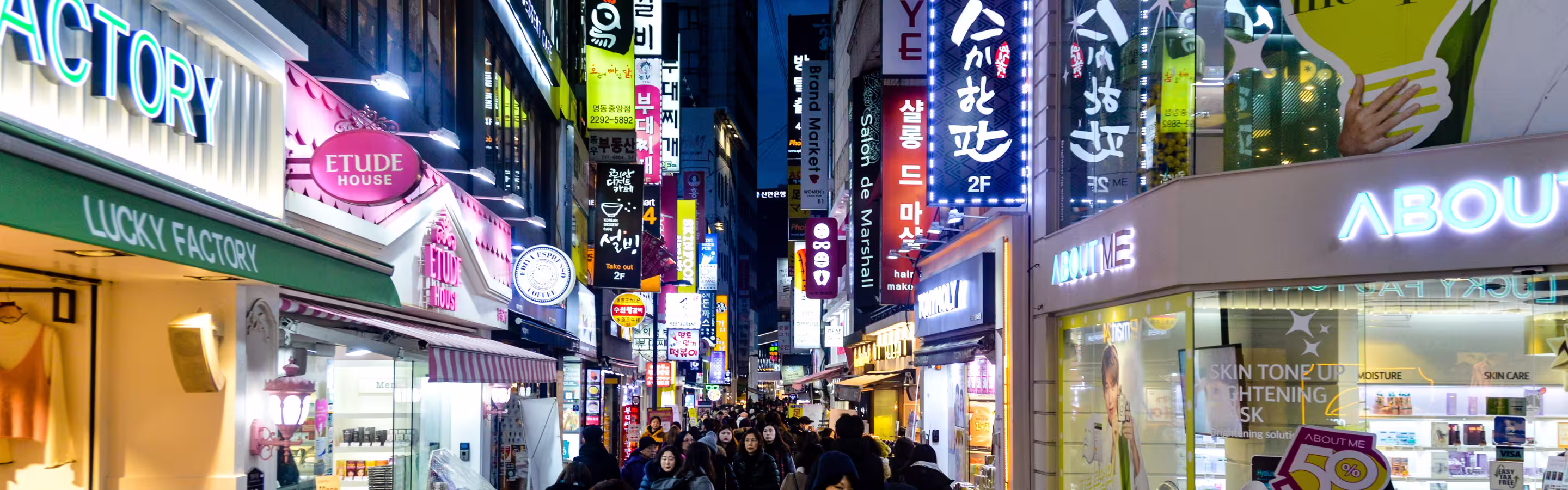 Calle peatonal de Myeongdong de noche, Seúl — zona de compras, cosméticos y comida callejera